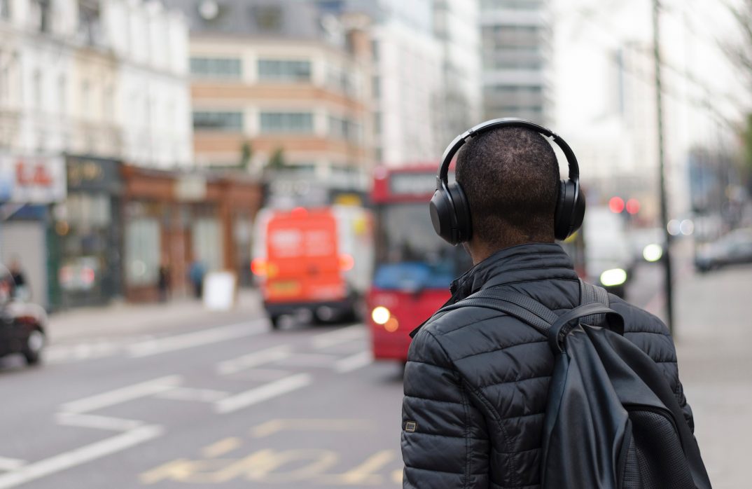 un homme écoute un podcast dans la rue